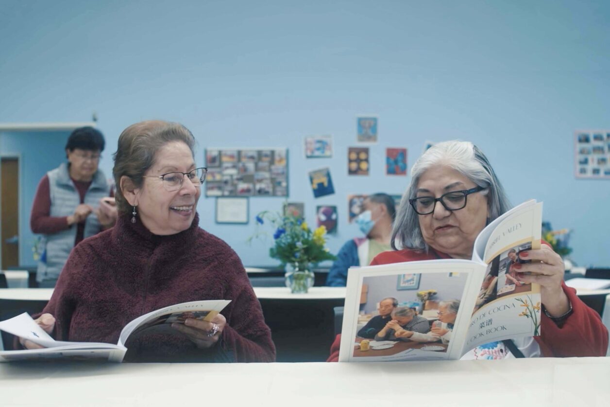 Seniors in the San Gabriel Valley Service Center review the cookbook they created.