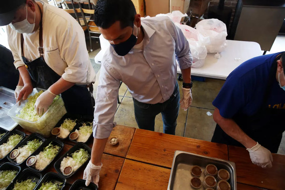 Assemblymember Miguel Santiago helps prepare hot meals for homebound seniors and low-income residents in Little Tokyo at JiST Cafe. (Photo Credit: Dania Maxwell / Los Angeles Times)