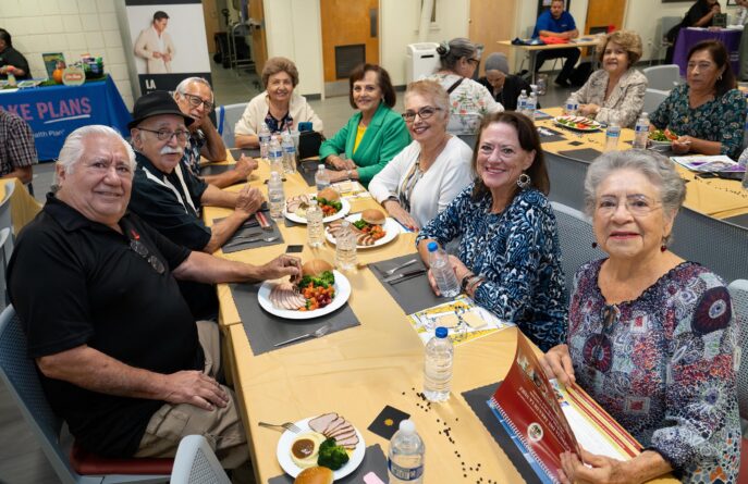 Group Of Senior Friends Having Lunch Together At A Restaurant Smiling at camera