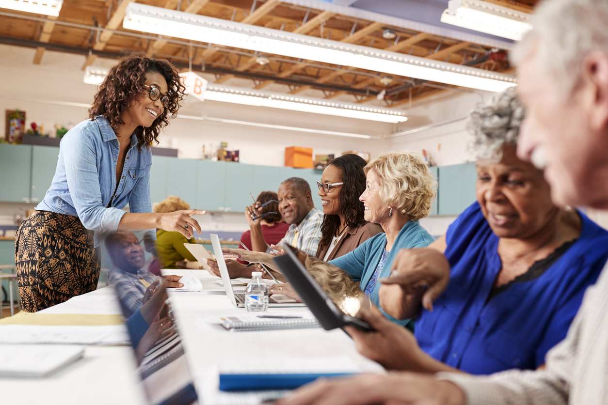 Group Of Retired Seniors Attending Art Class In Community Centre With Teacher