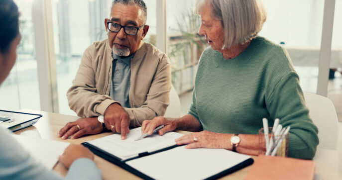 Lawyer with old couple advising.