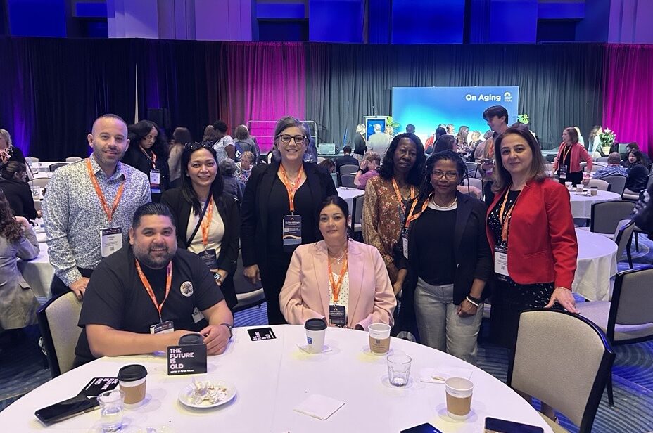 A group of people sit at a table at the On Aging conference.